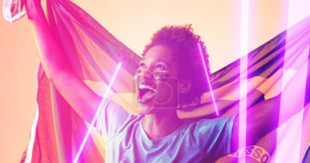 Photo for Cheerful biracial female soccer player with brazilian flag screaming over illuminated lines. Composite, sport, competition, match, face paint, mouth open, patriotism, achievement and abstract concept. - Royalty Free Image