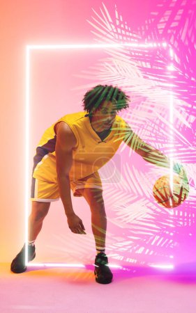 Photo for Full length of male biracial player dribbling basketball by illuminated plants and square. Copy space, composite, sport, competition, illustration, glowing, nature and shape concept. - Royalty Free Image