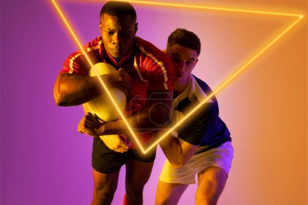 Foto de Opositores masculinos de rugby multirraciales que abordan la pelota mediante un triángulo iluminado sobre un fondo degradado. Copiar espacio, compuesto, rugby, forma, deporte, competición, juego, partido y concepto abstracto. - Imagen libre de derechos