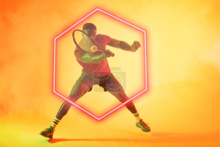 Téléchargez les photos : Joueur afro-américain jouant au tennis sur hexagone illuminé sur fond dégradé. Espace de copie, composite, sport, compétition, forme, raquette, balle, fumée, match et concept abstrait. - en image libre de droit