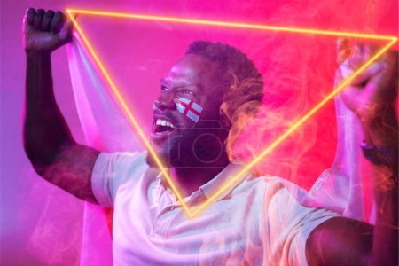 Photo for African american male fan with england flag and face paint screaming by illuminated triangle. Copy space, composite, sport, competition, soccer, shape, support, cheering, match and abstract concept. - Royalty Free Image