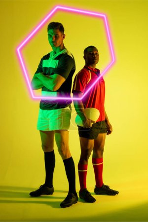 Téléchargez les photos : Divers adversaires de rugby masculin confiants debout par hexagone illuminé sur fond jaune. Espace de copie, composite, sport, forme, compétition, jeu, ballon, match et concept abstrait. - en image libre de droit