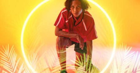 Photo for Biracial female rugby player kneeling down in illuminated circle and plant on abstract background. Copy space, ball, composite, sport, competition, shape, nature, playing, match concept. - Royalty Free Image