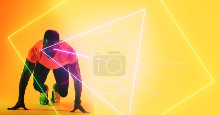 Photo for African american male athlete at starting position over geometric shapes on yellow background. Copy space, composite, illuminated, sprinting, sport, competition, running, racing, shape and abstract. - Royalty Free Image