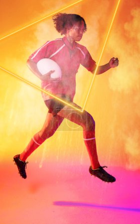 Photo for Illuminated triangle over biracial female rugby player with ball running on smoky background. Copy space, composite, sport, competition, shape, playing, match and abstract concept. - Royalty Free Image
