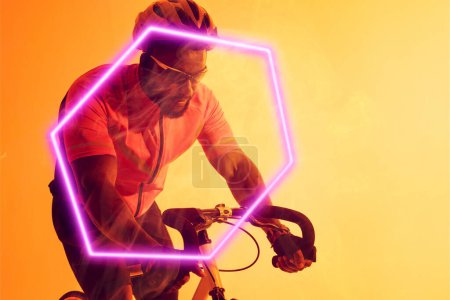 Téléchargez les photos : Cycliste afro-américain portant un casque et des lunettes de vélo d'équitation par hexagone illuminé. Espace de copie, composite, sport, cyclisme, course, compétition, jaune, forme et concept abstrait. - en image libre de droit