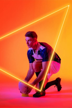 Photo for Caucasian male player placing rugby ball on stand by illuminated triangle over gradient background. Copy space, composite, sport, shape, competition, playing, match and abstract concept. - Royalty Free Image