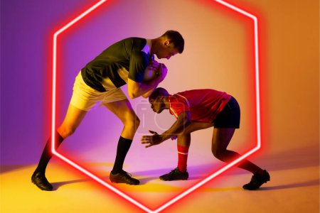 Photo for Multiracial male rugby opponents tackling ball by illuminated hexagon on gradient background. Copy space, composite, sport, competition, playing, shape, match and abstract concept. - Royalty Free Image