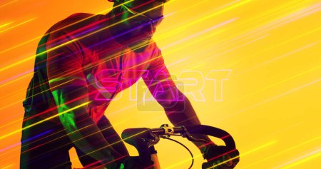 Téléchargez les photos : Mouvement flou de lumières colorées éclairées sur un vélo d'équitation d'athlète afro-américain. Composite, sport, cyclisme, course, compétition, forme et concept abstrait. - en image libre de droit
