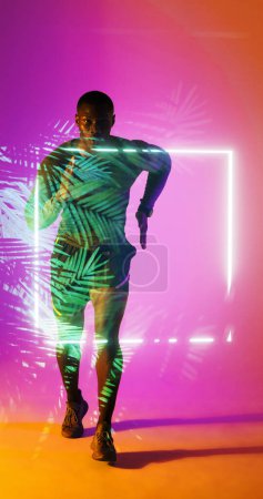 Photo for Full length of african american rugby player running towards illuminated square and plants. Copy space, composite, sport, competition, shape, nature, playing, match and abstract concept. - Royalty Free Image
