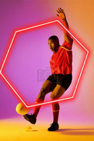 Photo for African american male rugby player kicking ball by illuminated hexagon over gradient background. Copy space, composite, sport, competition, shape, playing, match and abstract concept. - Royalty Free Image