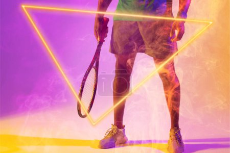 Photo for Low section of african american male tennis player with racket amidst smoke by illuminated triangle. - Royalty Free Image