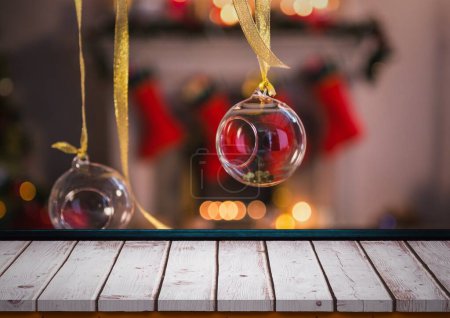 Téléchargez les photos : Close-up of glass baubles tied up with ribbons hanging by blank wooden table at home. Copy space, unaltered, decorations, celebration, christmas festivity, tradition and winter holiday concept. - en image libre de droit
