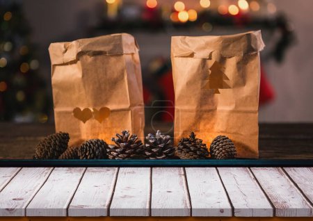 Téléchargez les photos : Gros plan de sacs en papier brun déchirés en forme d'arbre de Noël et de coeur avec des pommes de pin sur la table. Copier l'espace, fruit, amour, inaltéré, Noël, tradition, célébration et vacances d'hiver concept. - en image libre de droit
