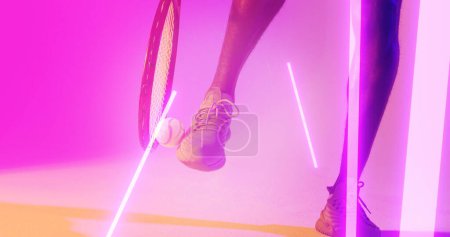 Photo for Low section of african american male tennis player with racket kicking ball over illuminated lines. Copy space, composite, sport, competition, neon, leg, pink, shoe and abstract concept. - Royalty Free Image