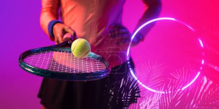 Téléchargez les photos : Illuminated circle and plant by midsection of african american female player with racket and ball. Copy space, composite, tennis, sport, competition, shape, nature, playing, match, hand, abstract. - en image libre de droit