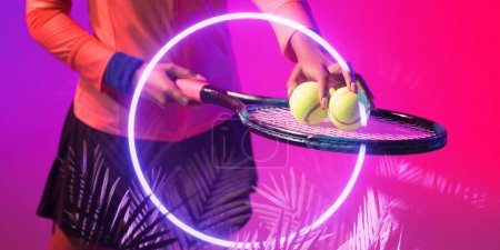 Téléchargez les photos : Illuminated circle and plant over midsection of african american female player with racket and balls. Copy space, composite, tennis, sport, competition, shape, nature, playing, match, hand, abstract. - en image libre de droit