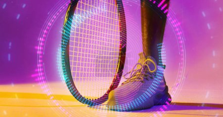 Photo for Low section of african american male tennis player with racket over illuminated circular pattern. Copy space, composite, sport, competition, neon, leg, shape, shoe and abstract concept. - Royalty Free Image