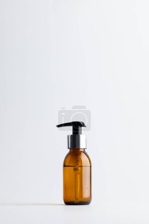 Foto de Image of glass bottle with pump and copy space on white background. Plastic free beauty, health and beauty, sustainability concept. - Imagen libre de derechos