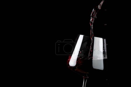 Téléchargez les photos : Glass of red wine on black background, with copy space. Wine week, drink and celebration concept. - en image libre de droit
