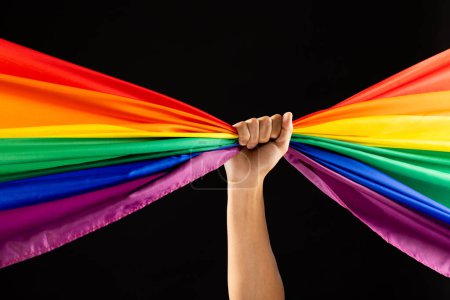 Foto de Bandera de color arco iris con espacio para copiar sobre fondo negro. Mes del orgullo, igualdad, lgbt y concepto de derechos humanos. - Imagen libre de derechos