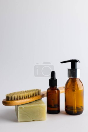 Foto de Image of glass bottles with pumps, soap, brush and copy space on white background. Plastic free beauty, health and beauty, sustainability concept. - Imagen libre de derechos