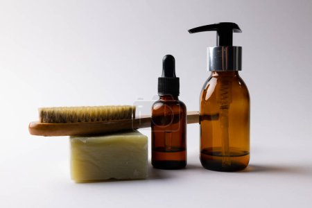 Foto de Image of glass bottles with pumps, soap, brush and copy space on white background. Plastic free beauty, health and beauty, sustainability concept. - Imagen libre de derechos