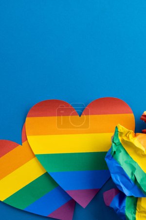 Téléchargez les photos : Close up of rainbow coloured hearts with copy space on blue background. Pride month, equality, lgbt and human rights concept. - en image libre de droit