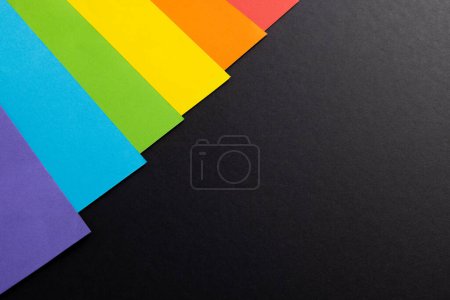 Foto de Primer plano de las tarjetas de color arco iris con espacio de copia sobre fondo negro. Mes del orgullo, igualdad, lgbt y concepto de derechos humanos. - Imagen libre de derechos