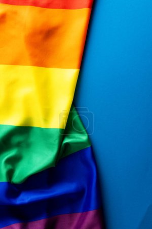 Foto de Bandera de color arco iris con espacio para copiar sobre fondo azul. Mes del orgullo, igualdad, lgbt y concepto de derechos humanos. - Imagen libre de derechos