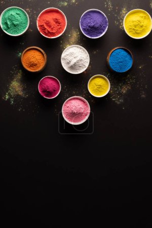 Photo for Close up of multi coloured powder in bowls with copy space on black background. Holi festival, colour, hindu tradition and celebration concept. - Royalty Free Image