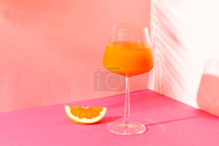 Foto de Vaso con zumo de naranja en espacio rosa con sombras. Bebidas, cócteles, bebidas y concepto de fiesta. - Imagen libre de derechos