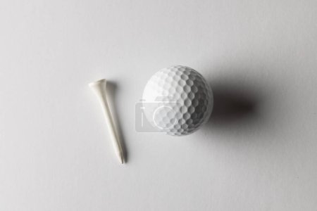 Téléchargez les photos : Vue grand angle de balle de golf blanche et tee-shirt de golf avec espace de copie sur fond blanc. Golf, sport et concept de compétition. - en image libre de droit