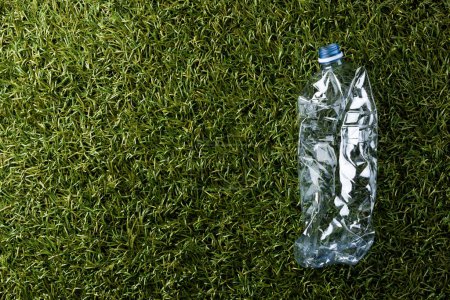 Foto de Close up of plastic bottle on grass background with copy space. Global ecology and recycling concept. - Imagen libre de derechos