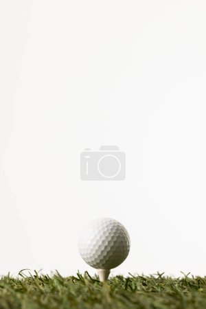 Téléchargez les photos : Close up of white golf ball on tee on grass with copy space on white background. Golf, sports and competition concept. - en image libre de droit