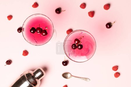 Photo for Glasses with drinks and fruits over pale pink background with shadows. Drinks, cocktails, beverages and party concept. - Royalty Free Image