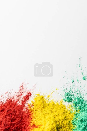 Téléchargez les photos : Gros plan de poudre multicolore et copiez l'espace sur fond blanc. Festival Holi, couleur, tradition hindoue et concept de célébration. - en image libre de droit