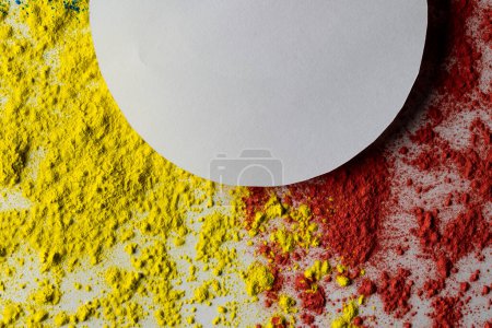 Photo for Close up of red and yellow coloured powder and white circle with copy space on white background. Holi festival, colour, hindu tradition and celebration concept. - Royalty Free Image