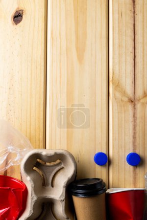 Photo for Close up of paper, plastic cups trash on wooden background with copy space. Global ecology and recycling concept. - Royalty Free Image
