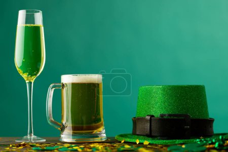 Foto de Image of beer and champagne glasses, green hat and copy space on green background. St patrick's day, irish tradition and celebration concept. - Imagen libre de derechos