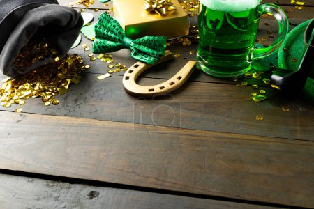 Foto de Image of green hat, green clover, horse shoe and copy space on wooden background. St patrick's day, irish tradition and celebration concept. - Imagen libre de derechos