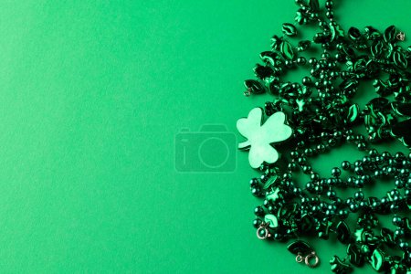 Photo for Image of green clover and jewellery and copy space on green background. St patrick's day, irish tradition and celebration concept. - Royalty Free Image