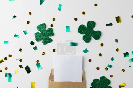 Photo for Image of green clover and white paper with copy space on white background. St patrick's day, irish tradition and celebration concept. - Royalty Free Image