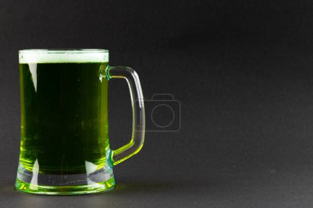 Foto de Imagen de vidrio con cerveza verde y espacio para copiar sobre fondo gris. Día de San Patricio, tradición irlandesa y concepto de celebración. - Imagen libre de derechos