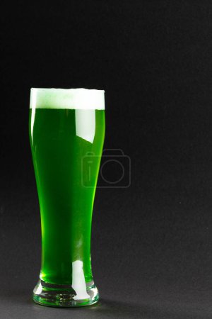 Foto de Imagen de vidrio con cerveza verde y espacio para copiar sobre fondo gris. Día de San Patricio, tradición irlandesa y concepto de celebración. - Imagen libre de derechos