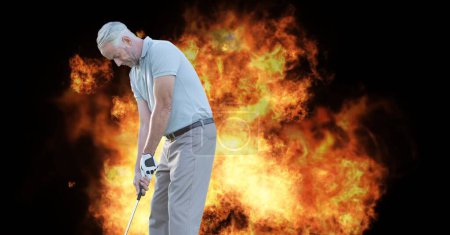 Photo for Caucasian senior male golf player holding club against fire flame effect on black background. retirement sports and active senior lifestyle concept - Royalty Free Image