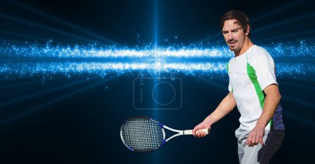 Foto de Jugador de tenis masculino caucásico sosteniendo una raqueta contra brillantes destellos azules sobre fondo oscuro. competencia deportiva y concepto de torneo - Imagen libre de derechos
