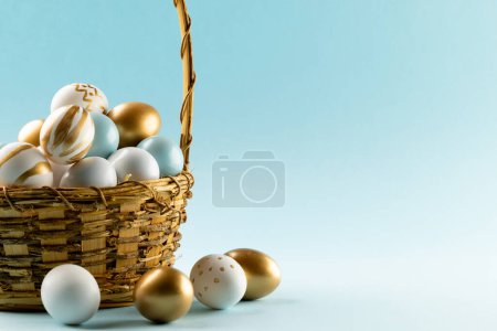 Photo for Image of multi coloured easter eggs in basket and copy space on blue background. Easter, religion, tradition and celebration concept. - Royalty Free Image