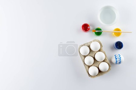 Photo for Image of easter eggs, paintbrush and paints with copy space on white background. Easter, religion, tradition and celebration concept. - Royalty Free Image