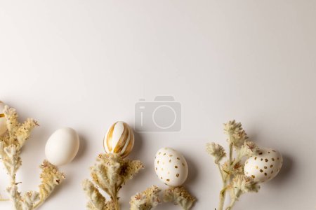 Téléchargez les photos : Image d'œufs de Pâques multicolores et de plantes avec espace de copie sur fond blanc. Pâques, religion, tradition et concept de célébration. - en image libre de droit